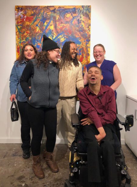 Visual Artist Stevie with his family in front of a recent piece